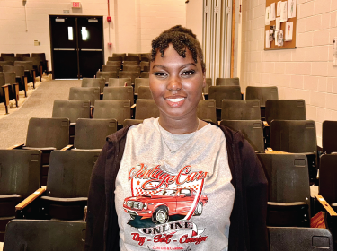 student smiling in auditorium